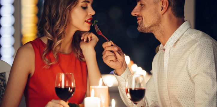 smiling-careful-man-feed-his-pretty-woman-friend-while-have-romantic-dinner-home-2