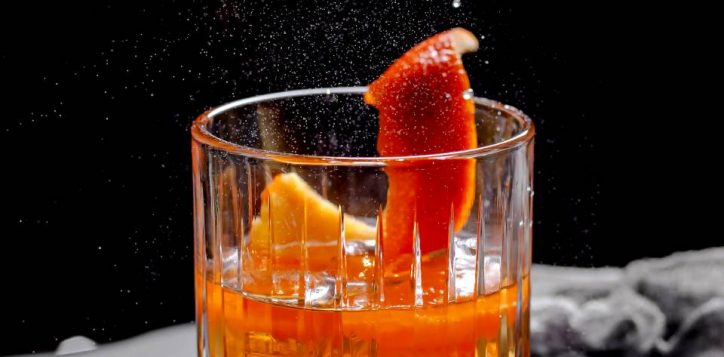 close-up-crystal-viski-glass-with-alcohol-cocktail-garnished-with-orange-zest-2
