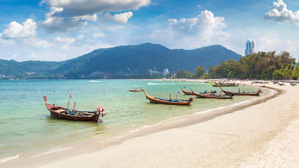 Traditional long tail boat on Patong beach and Andaman sea on Phuket in Thailand in a summer day